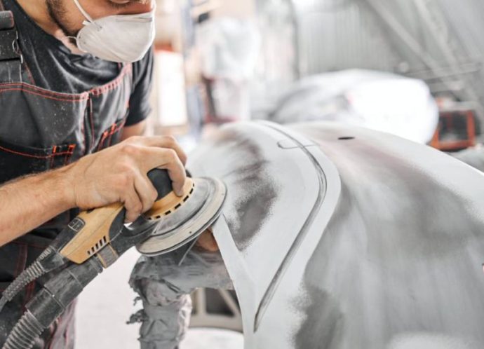 The,Mechanic,Works,With,A,Grinding,Tool.,Sanding,Of,Car