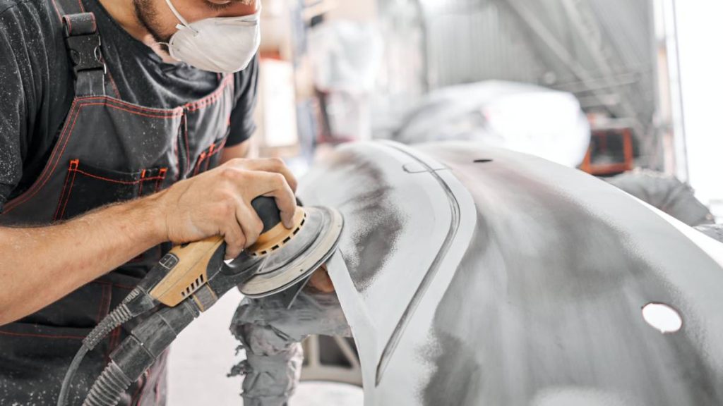 The,Mechanic,Works,With,A,Grinding,Tool.,Sanding,Of,Car